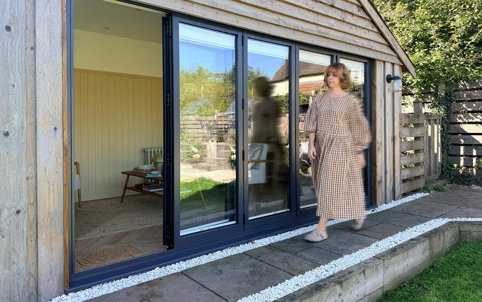 Therapist walking in front of a custom built counselling cabin in Leicestershire.